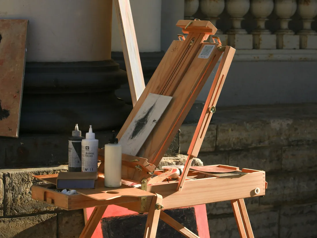 Caballete de madera con un lienzo montado en un taller de pintura iluminado por luz natural